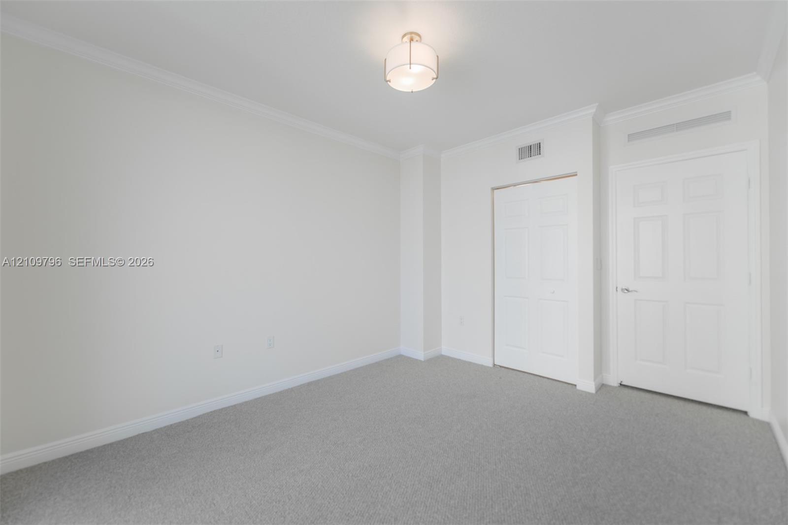 Neutral wall coloring, crown molding, wall-to-wall carpeting, dual-panel interior doors, and a semi-flush mount ceiling fixture Neutral wall coloring, crown molding, wall-to-wall carpeting, dual-panel interior doors, and a semi-flush mount ceiling fixture