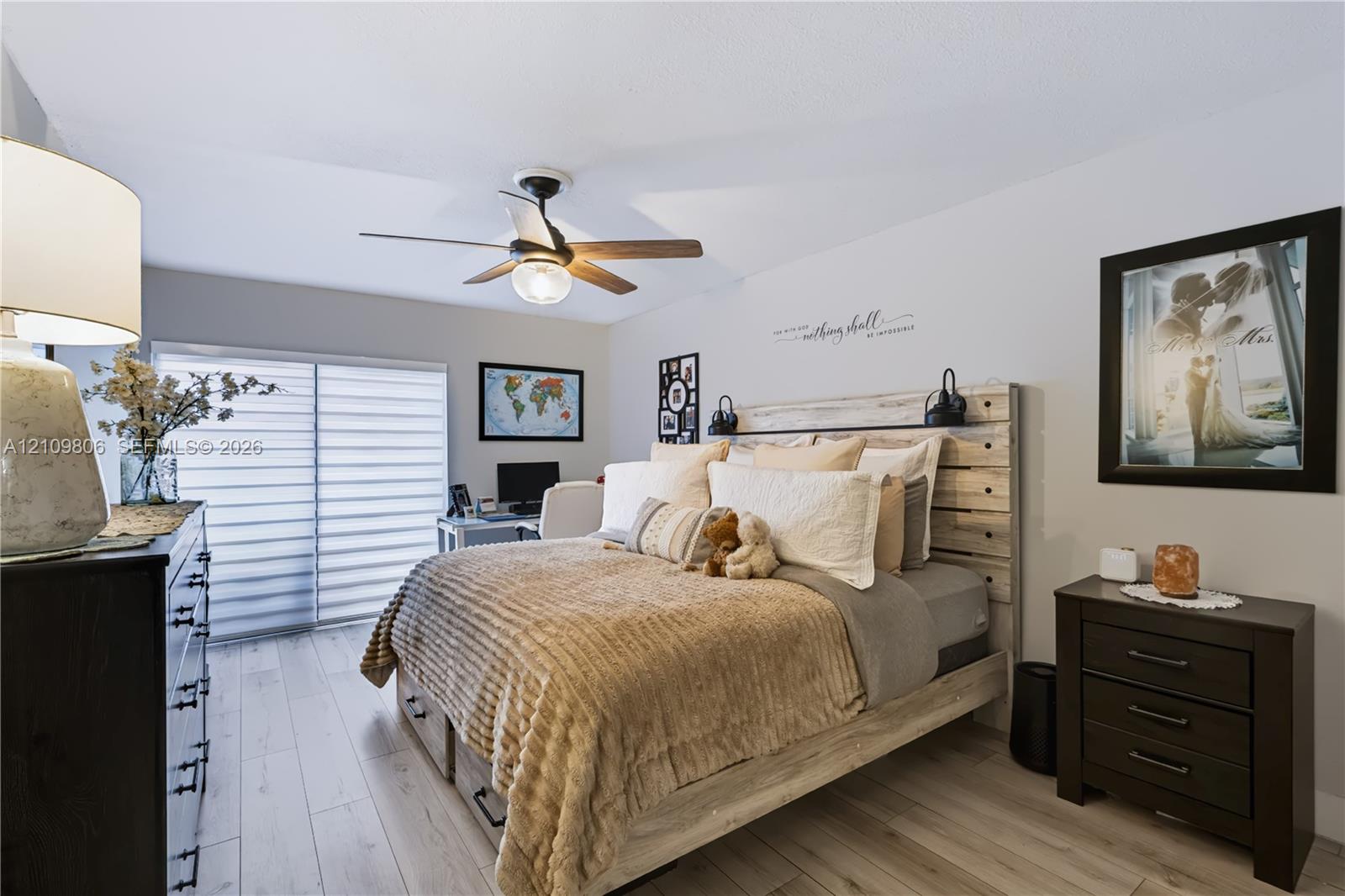 Room featuring wood-finish flooring, a ceiling fan with integrated lighting, and horizontal sliding window blinds