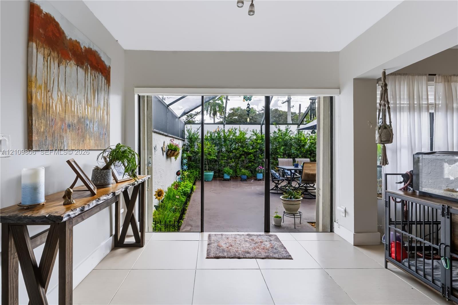 Interior featuring large-format tile flooring and sliding glass doors opening to a screened patio
