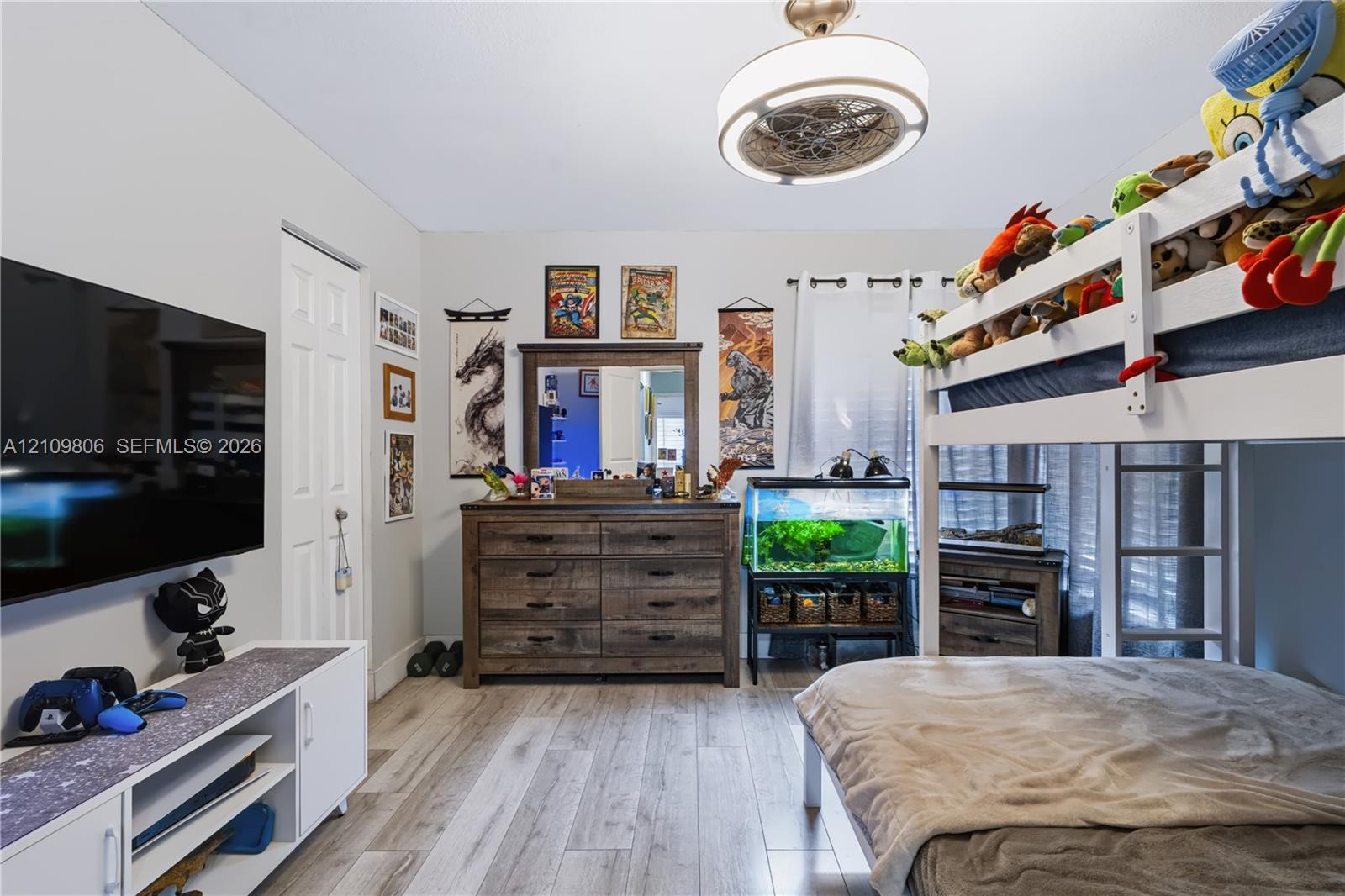 Wood-finish flooring, neutral wall tones, and a modern circular ceiling light fixture