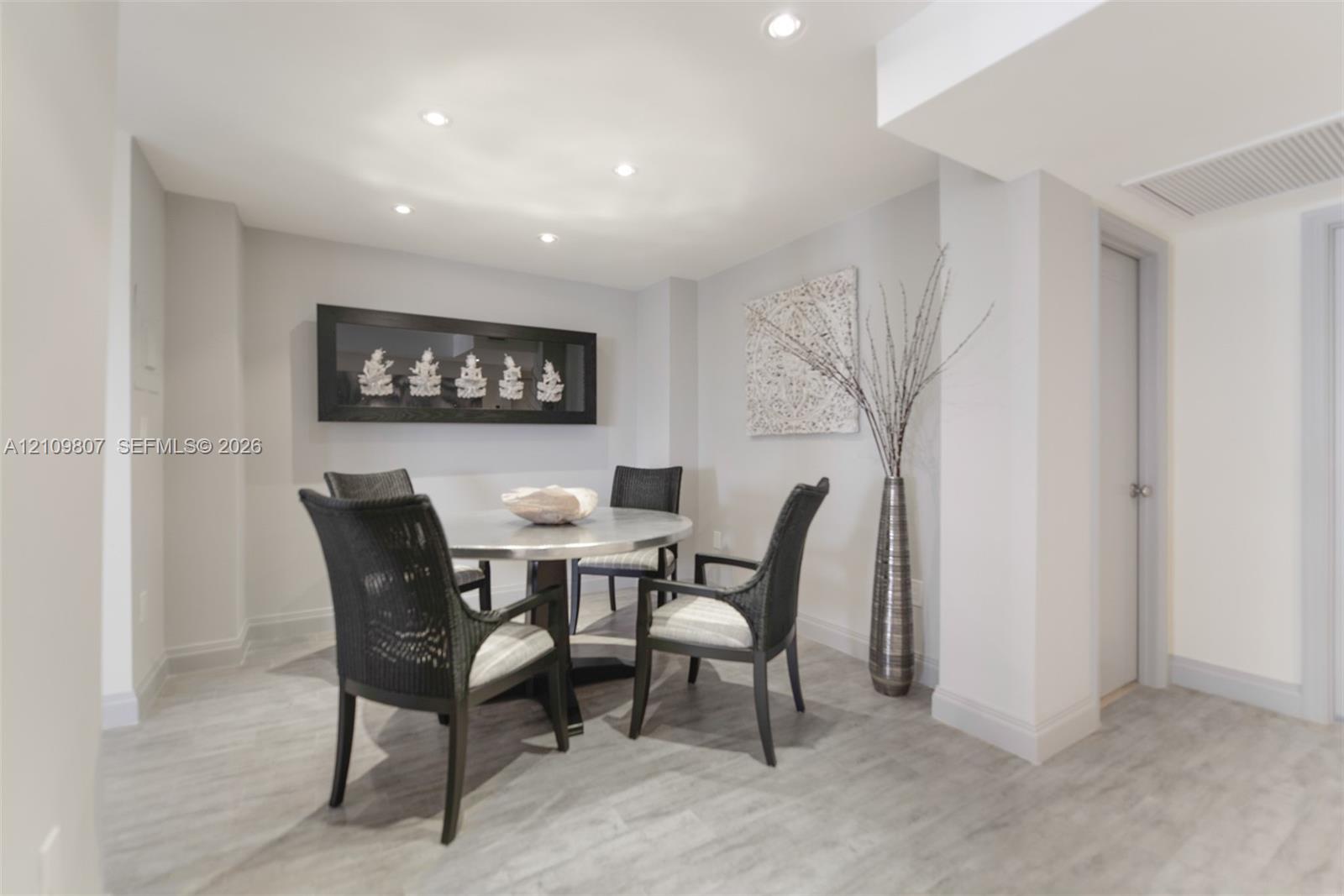 Neutral-toned space featuring recessed ceiling lighting, smooth-finish walls, and light wood-finish flooring