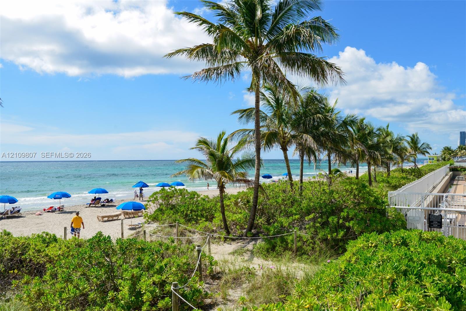 Direct access to sandy beach, perimeter security fencing, and mature tropical landscaping
