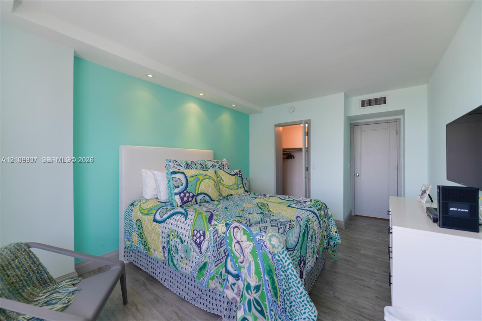 Bedroom featuring wood-finish flooring, recessed lighting, and a walk-in closet with built-in shelving