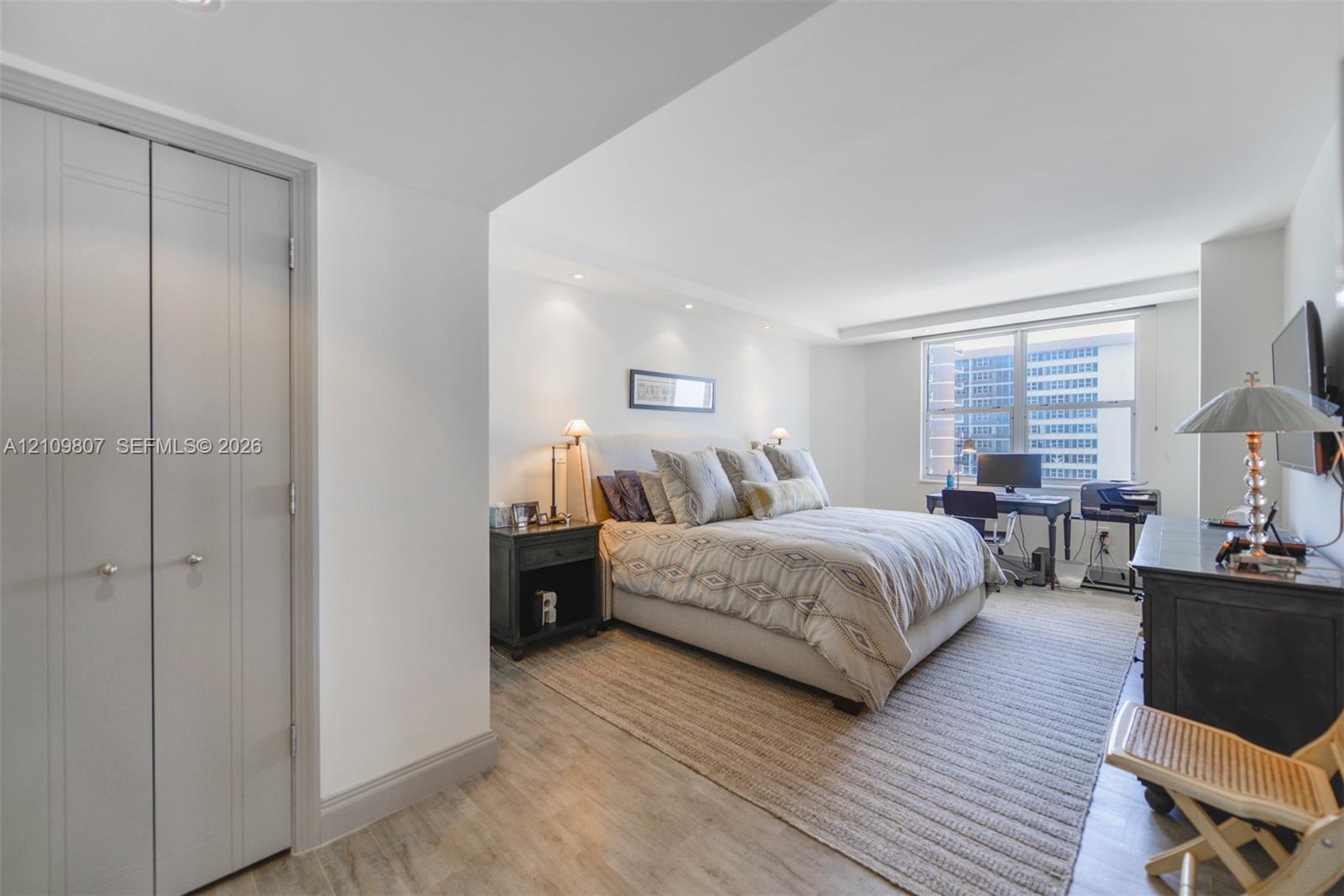 Spacious room featuring wood-finish flooring, recessed lighting, and a multi-pane window
