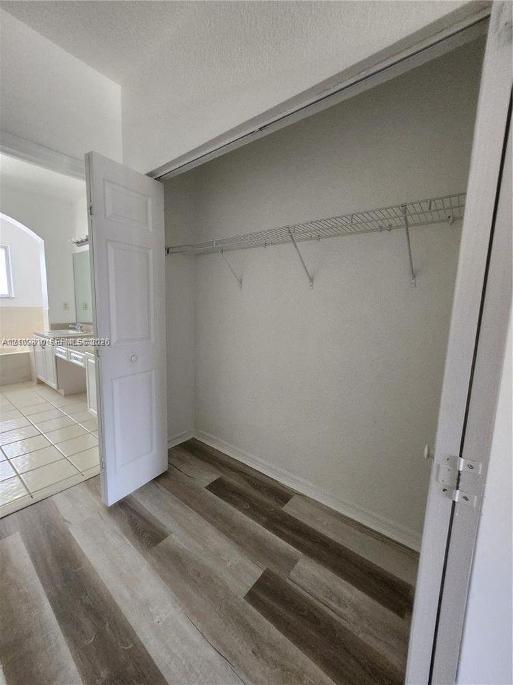 Reach-in closet featuring wire shelving, bi-fold doors, and wood-finish flooring