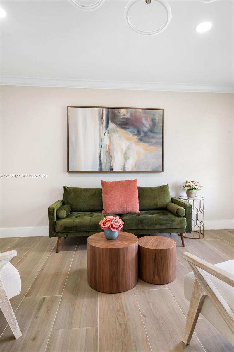 Wood-finish tile flooring, neutral wall palette, and recessed circular ceiling light fixtures Wood-finish tile flooring, neutral wall palette, and recessed circular ceiling light fixtures