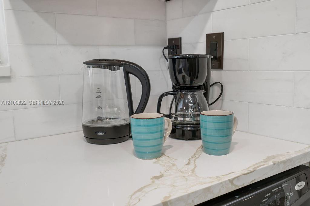 Quartz countertop featuring veined detailing and a white subway tile backsplash