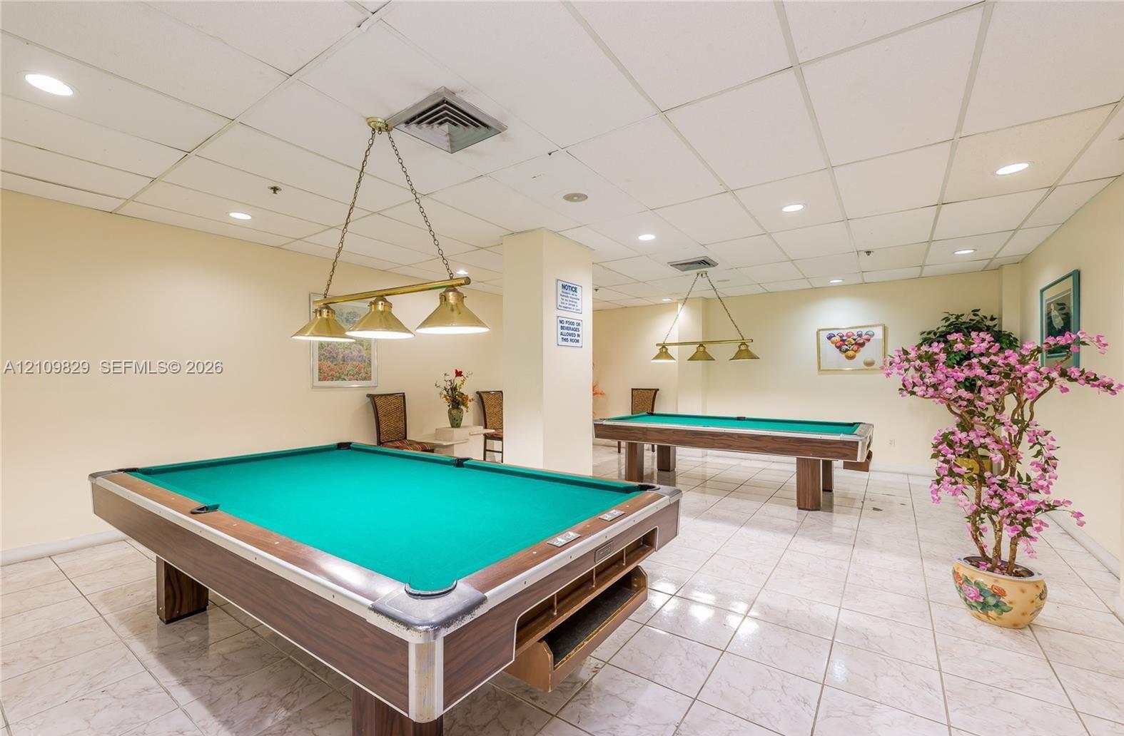 Spacious interior featuring recessed ceiling lighting, light-toned ceramic tile flooring, and multi-light hanging fixtures