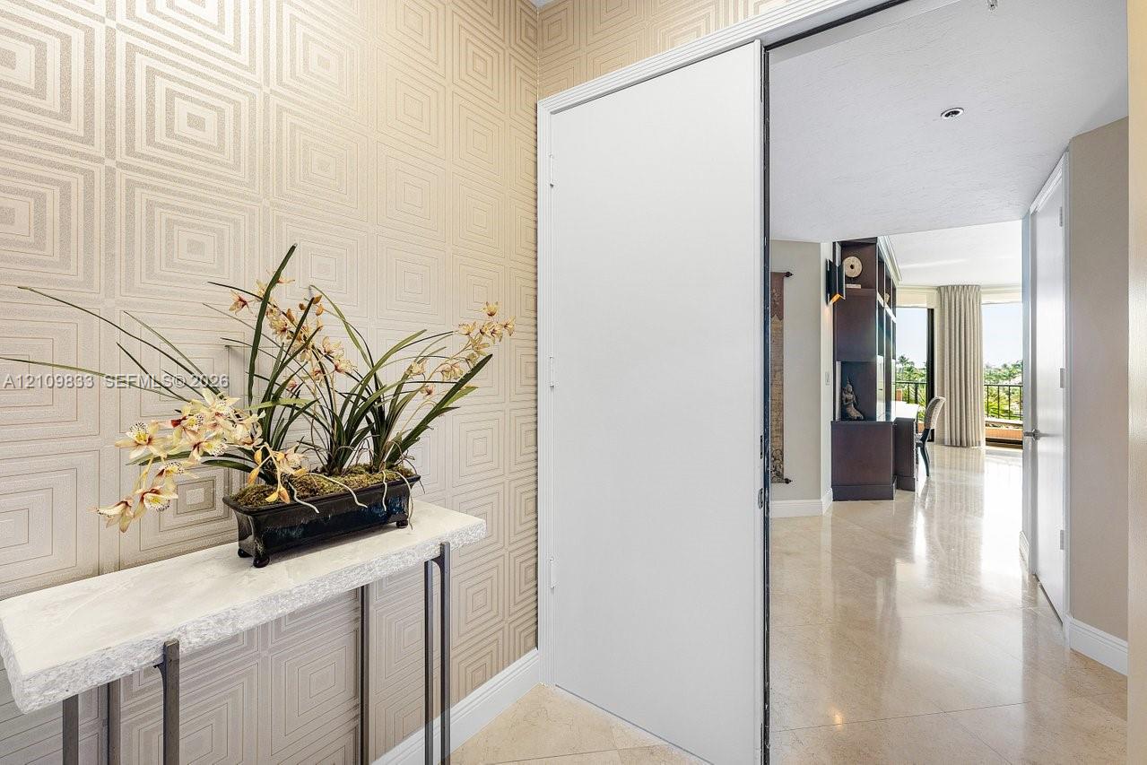 Entryway featuring geometric patterned wall coverings, stone-finish flooring, and a sliding door Entryway featuring geometric patterned wall coverings, stone-finish flooring, and a sliding door