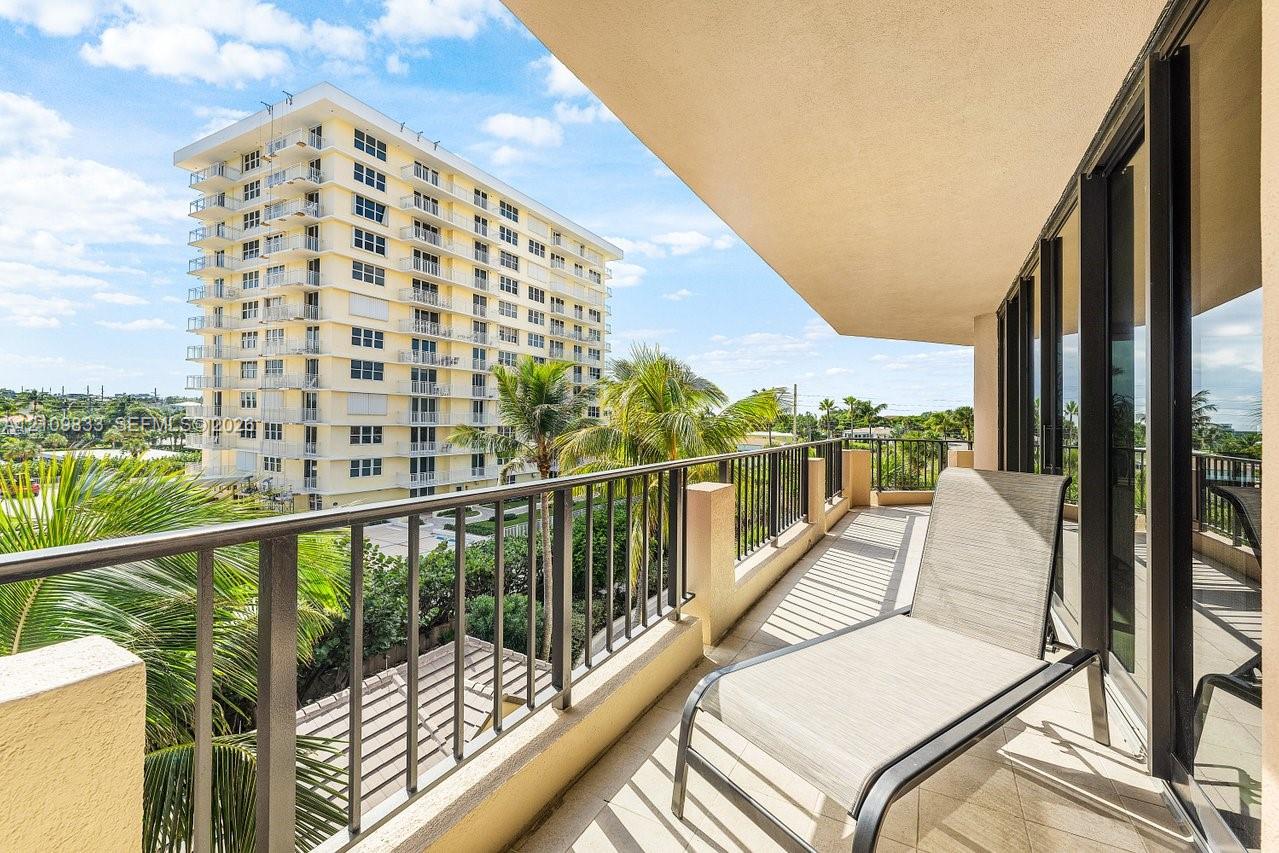 Private balcony with metal railings, tiled flooring, and sliding glass door access