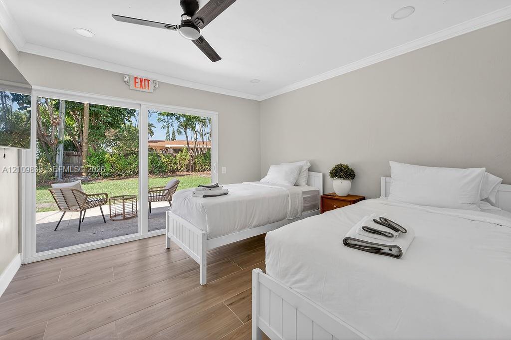 Wood-finish flooring, sliding glass patio doors, recessed lighting, and a modern ceiling fan