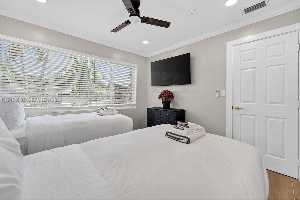 Neutral-toned room featuring wood-finish flooring, crown molding, recessed lighting, and a ceiling fan