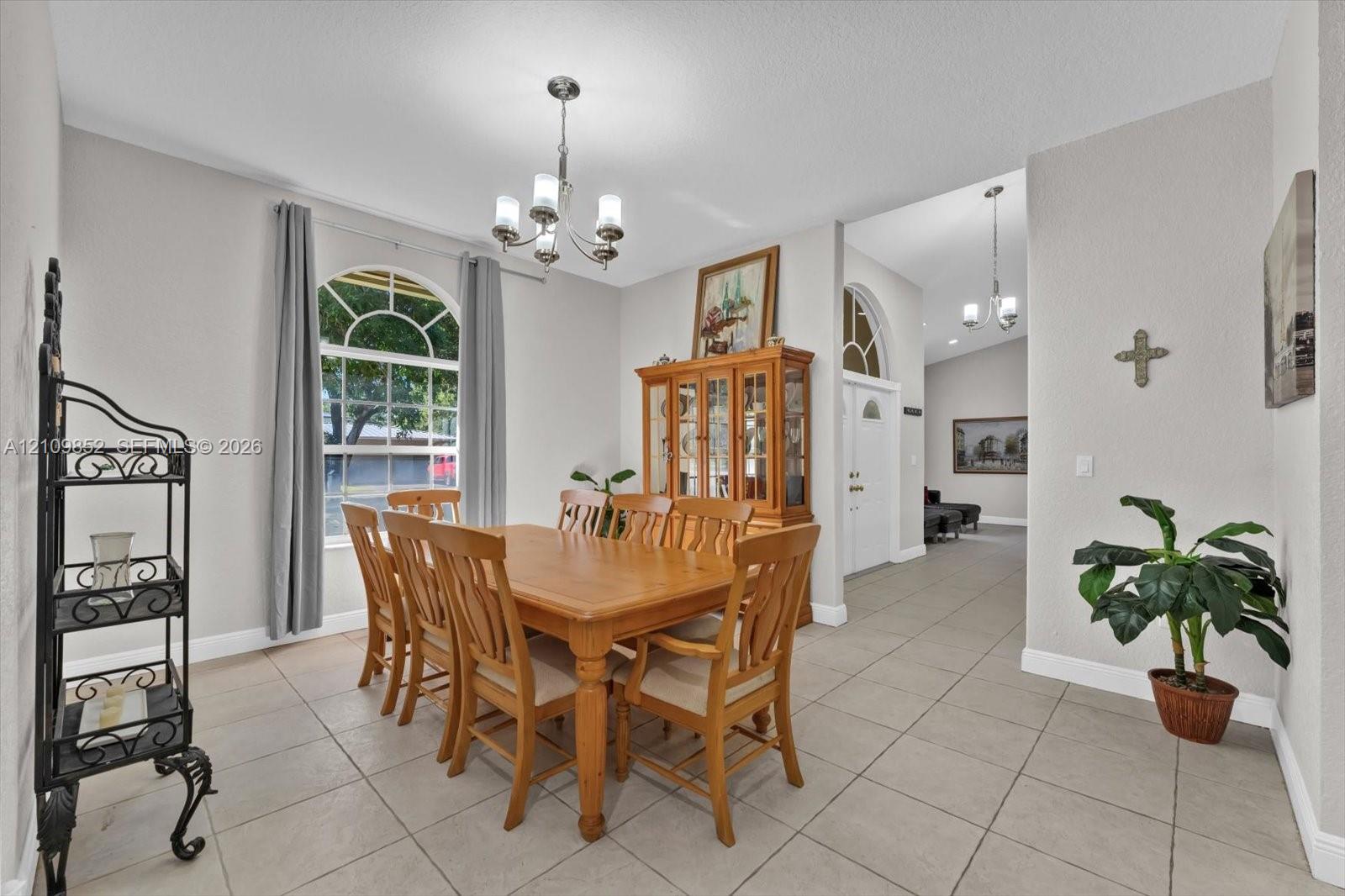Formal dining area with an arched window allowing for natural lighting to enter this space *