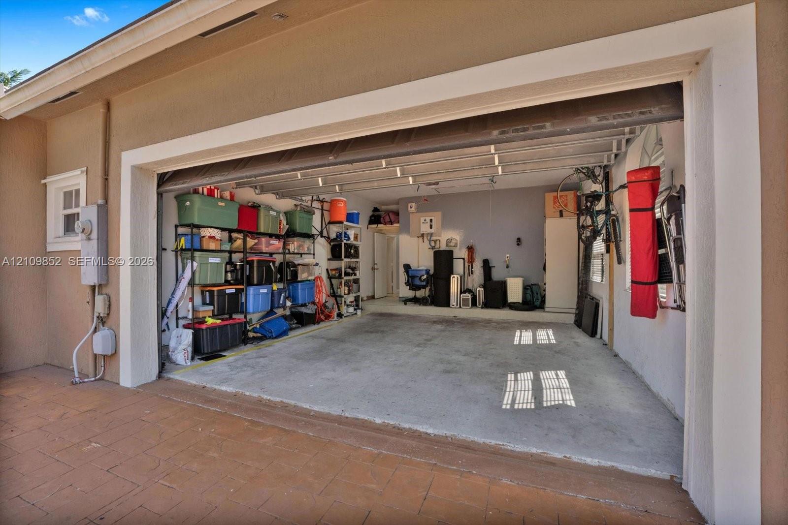 Two-car capacity garage featuring a concrete floor, finished interior walls, tankless water heater and capacity to charge your car *