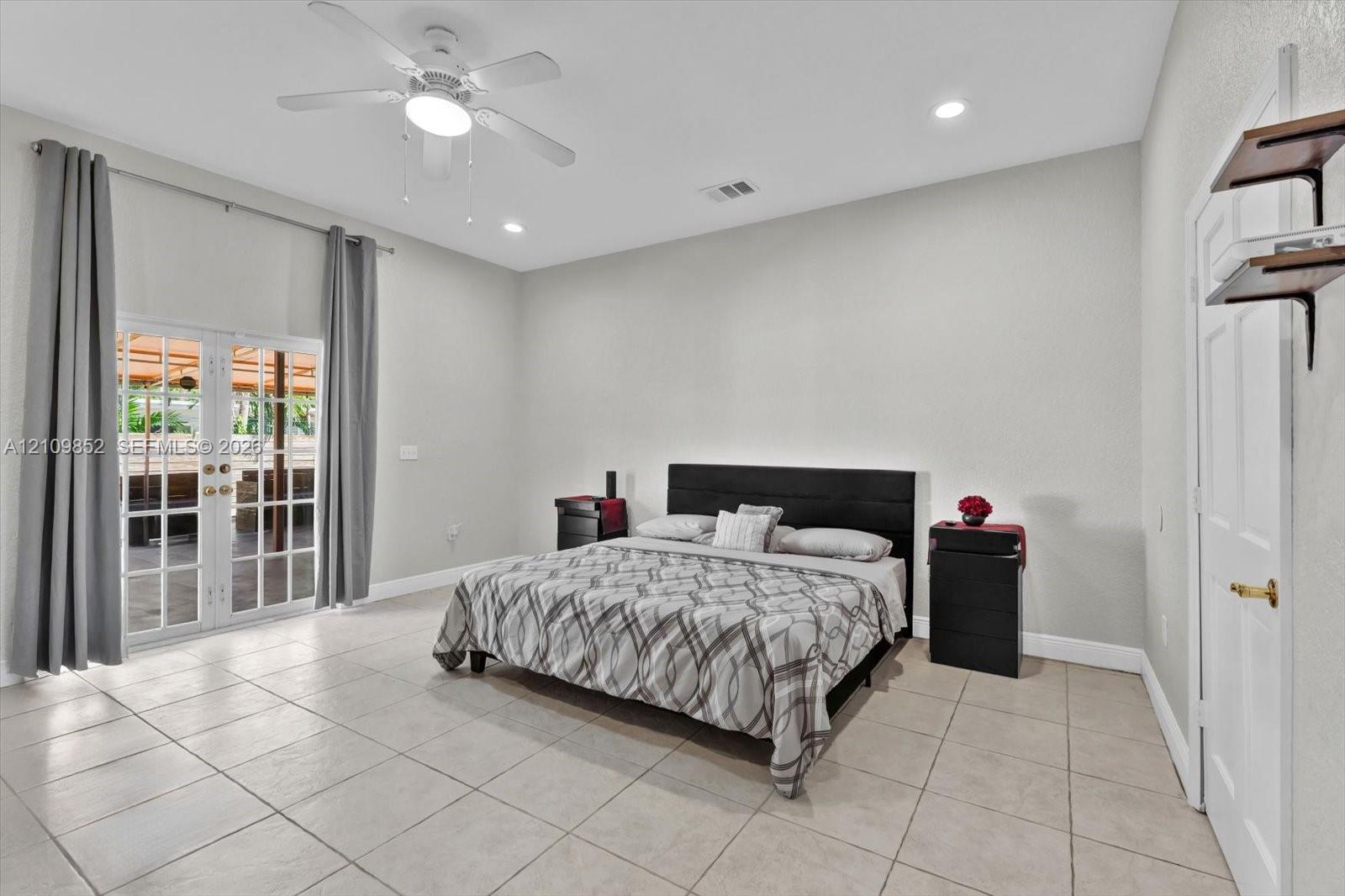 Main bedroom with double French doors leading to the covered patio *