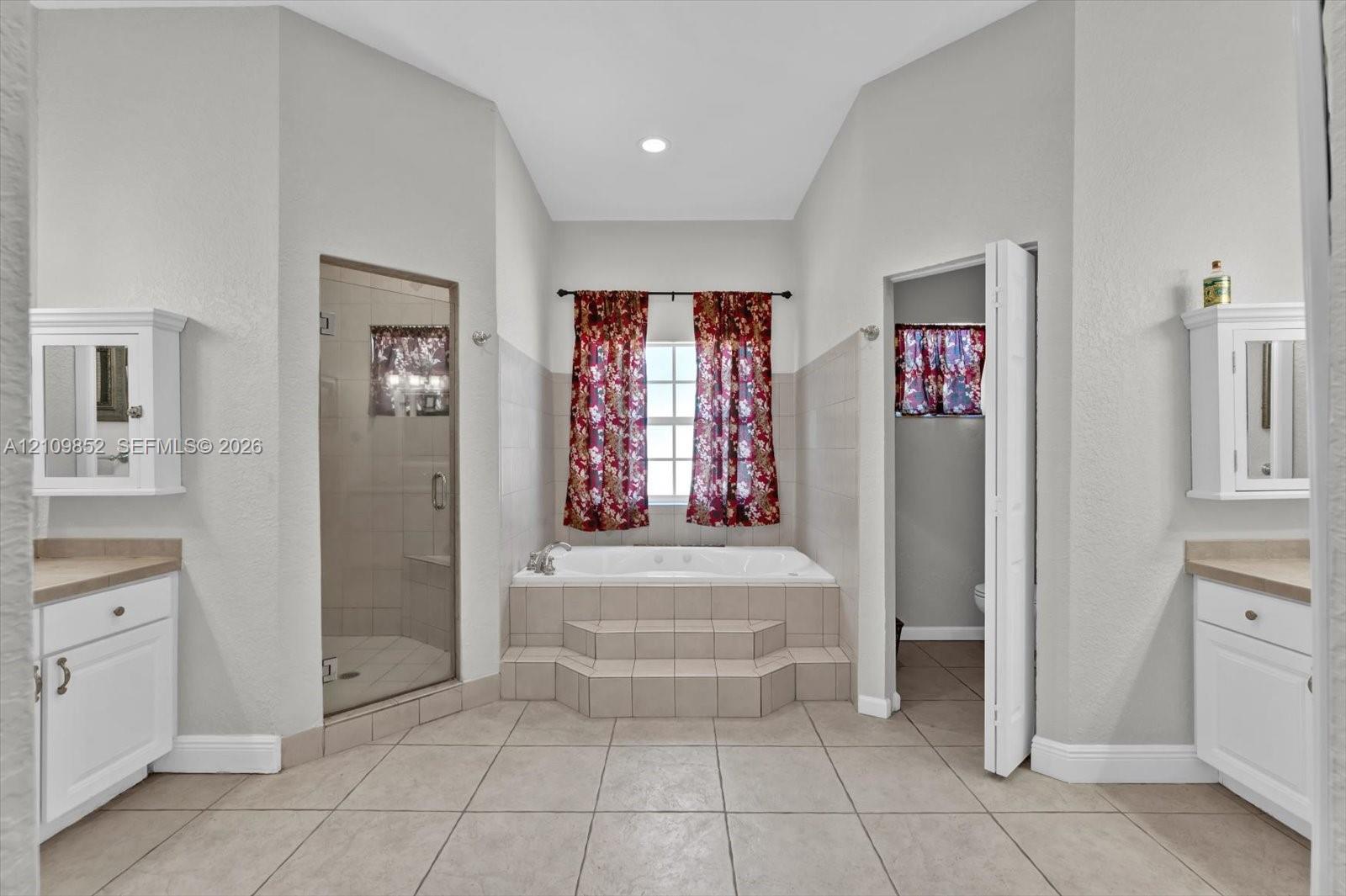 Soaking/spa tub with a separate glass-enclosed shower designed with multi high powered water jets, and dual vanities *