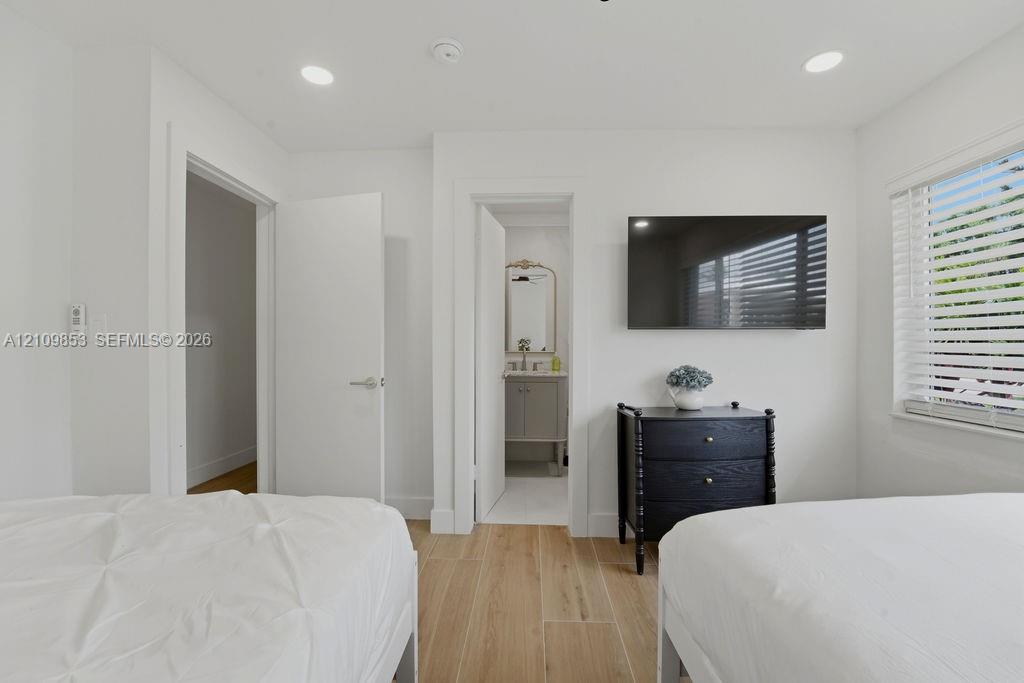 Wood-finish flooring, recessed lighting, and horizontal window blinds