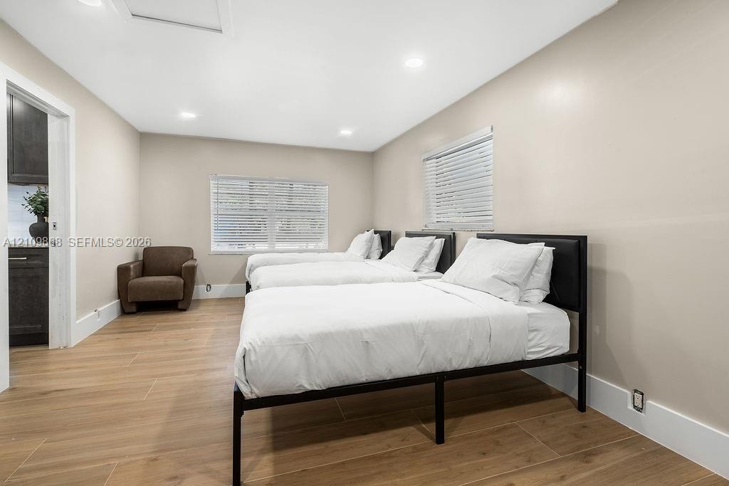 Neutral-toned interior featuring wood-finish flooring, recessed lighting, and horizontal window blinds