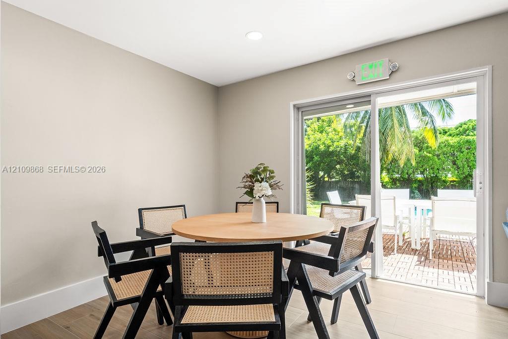 Neutral-toned interior space featuring wood-finish flooring, recessed lighting, and a sliding glass door providing outdoor exposure
