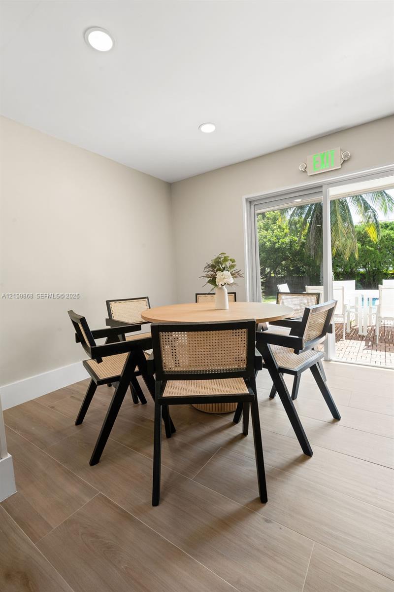 Neutral-toned interior space featuring wood-finish flooring, recessed lighting, and a sliding glass door