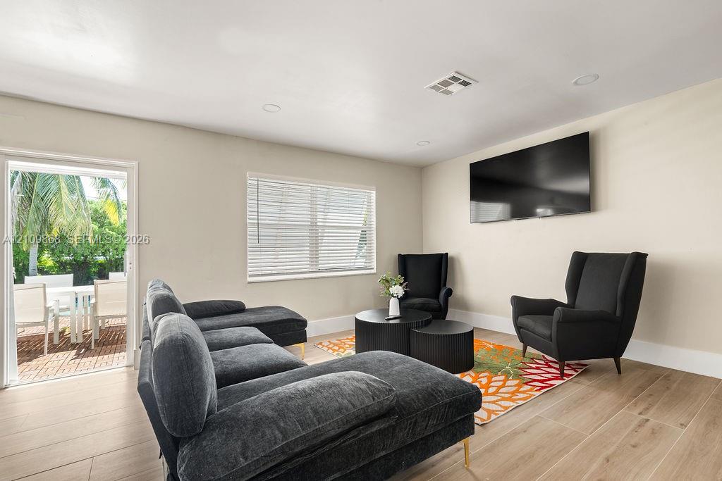 Neutral-toned interior featuring wood-finish flooring, recessed lighting, and a glass-paned door providing outdoor access