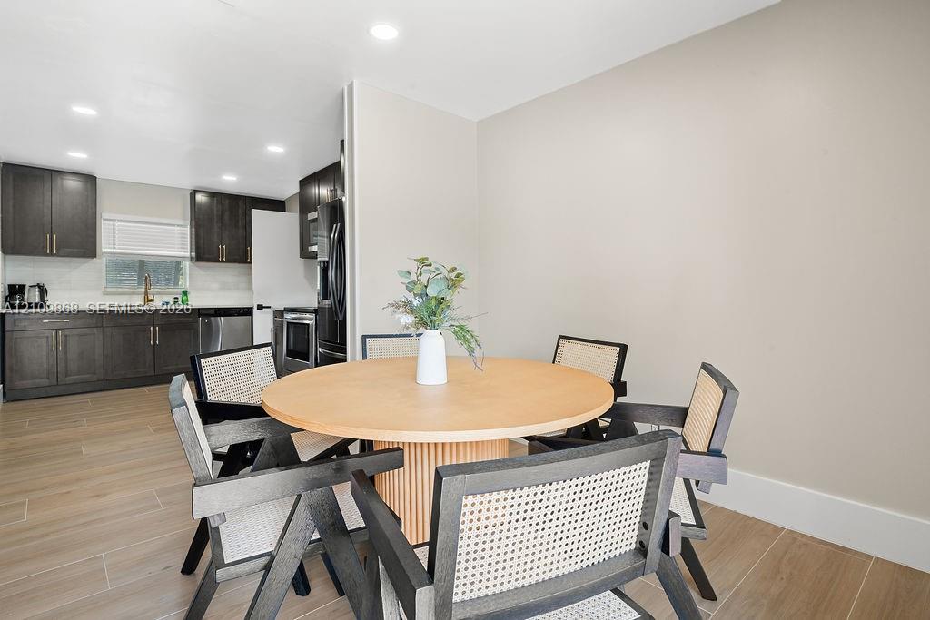 Kitchen featuring dark-toned shaker cabinetry, recessed lighting, wood-finish flooring, and stainless steel appliances