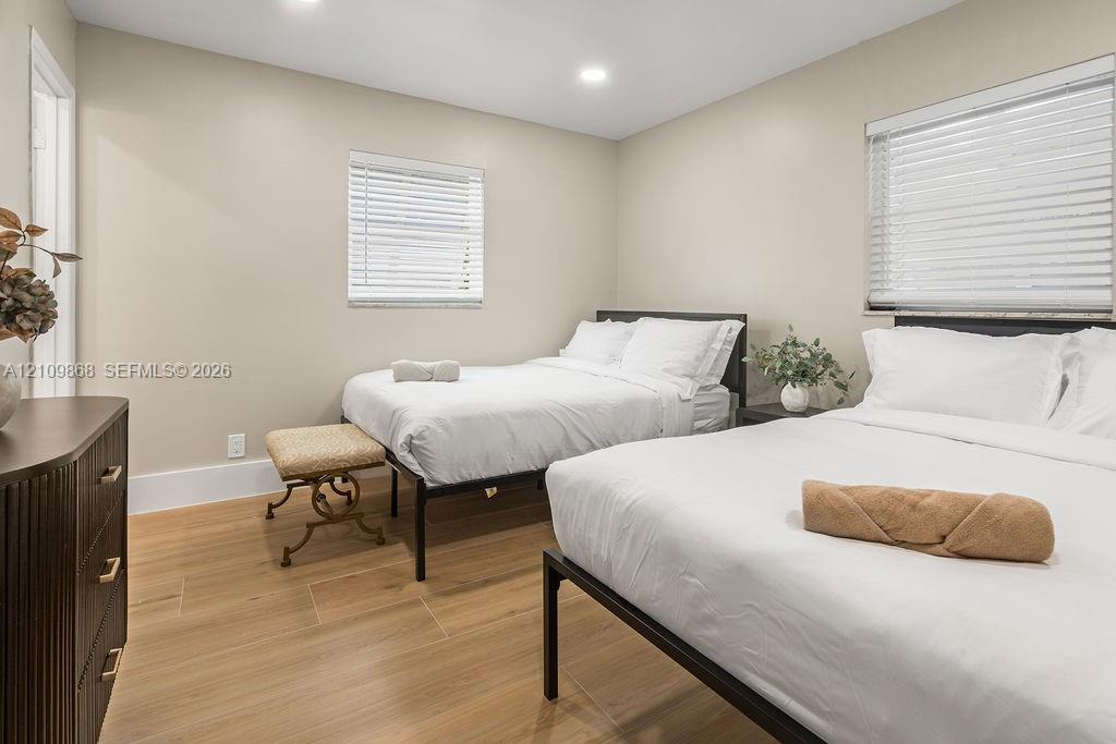 Neutral-toned interior space featuring wood-finish flooring, recessed lighting, and horizontal window blinds