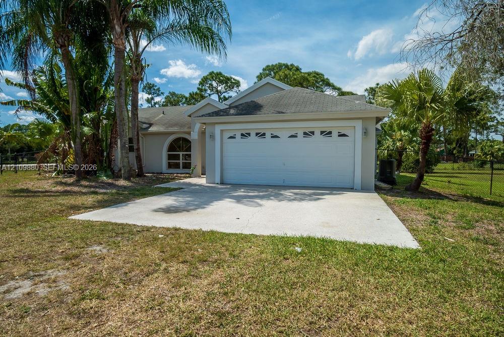 Single-story exterior featuring a concrete driveway, two-car garage with arched decorative windows, and stucco siding Single-story exterior featuring a concrete driveway, two-car garage with arched decorative windows, and stucco siding
