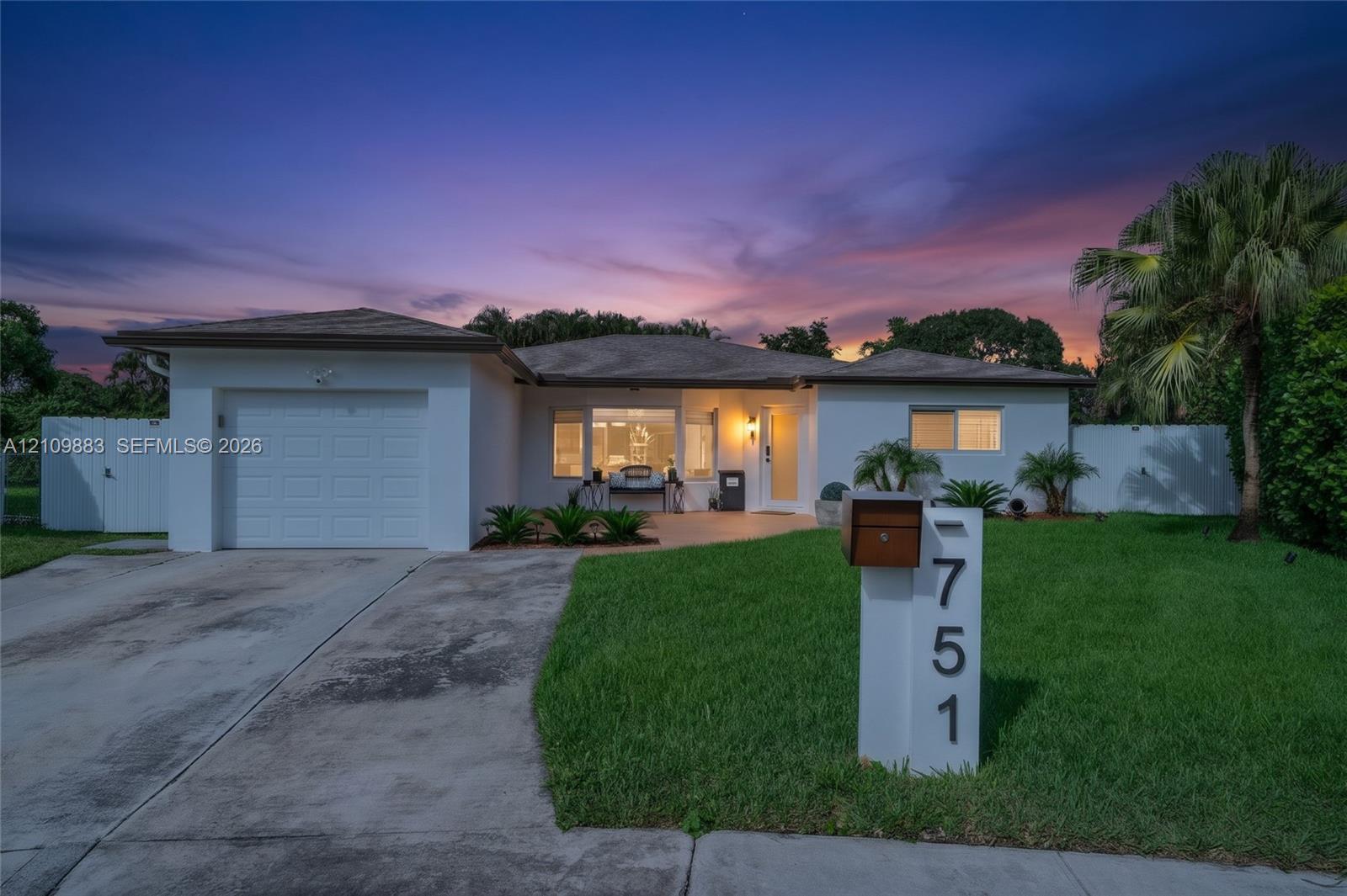 Single-story residence featuring a stucco exterior, integrated one-car garage, concrete driveway, and a front lawn with established landscaping