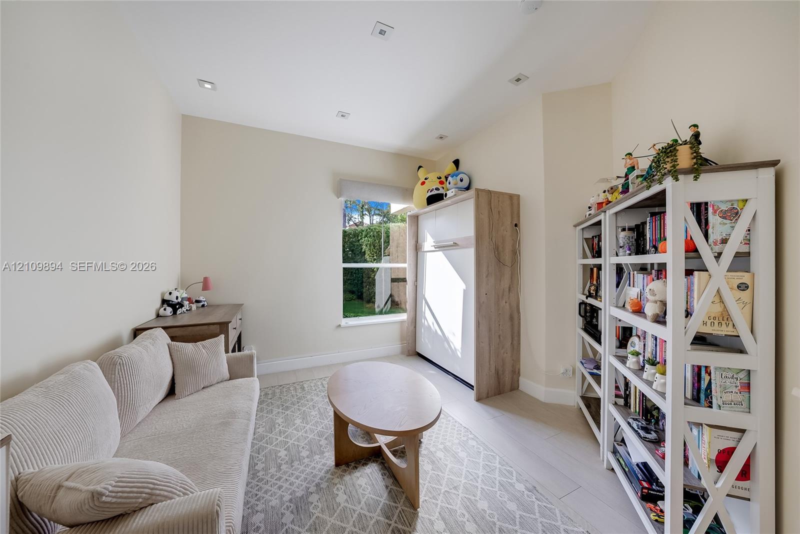 Interior room featuring neutral wall tones, wood-finish flooring, recessed ceiling lighting, and a single-pane window