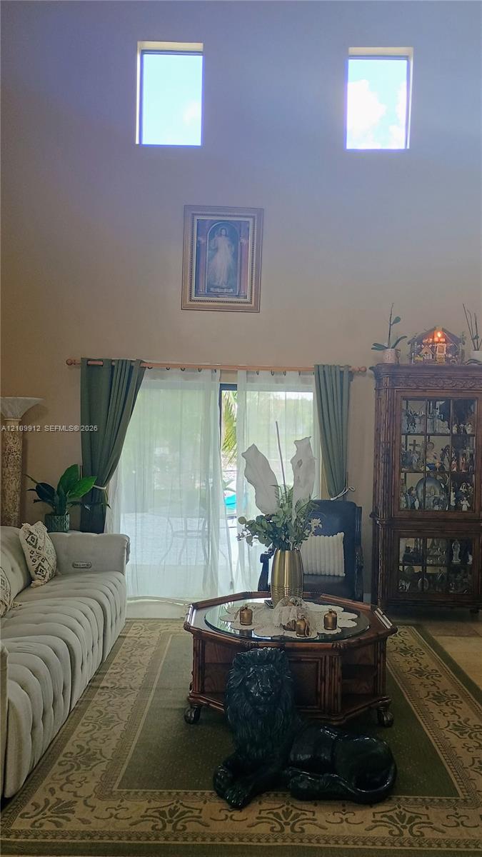 High ceilings featuring dual clerestory windows and sliding glass door access to the exterior