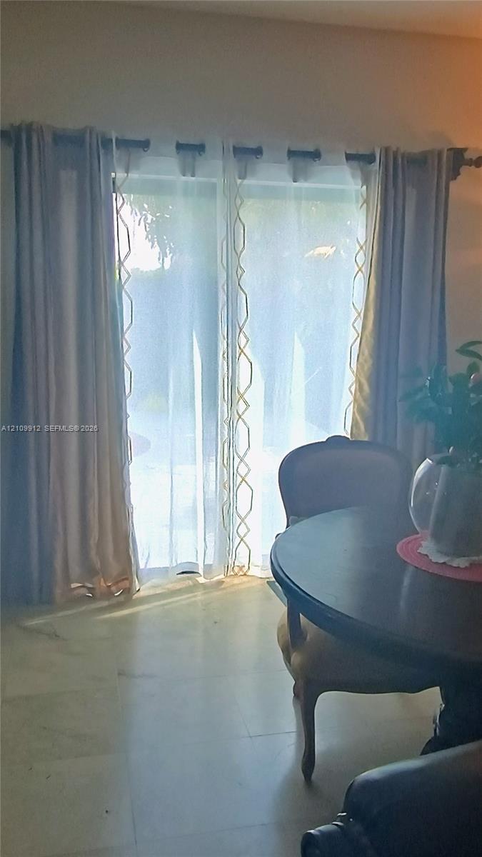 Sliding glass door with neutral stone-finish flooring