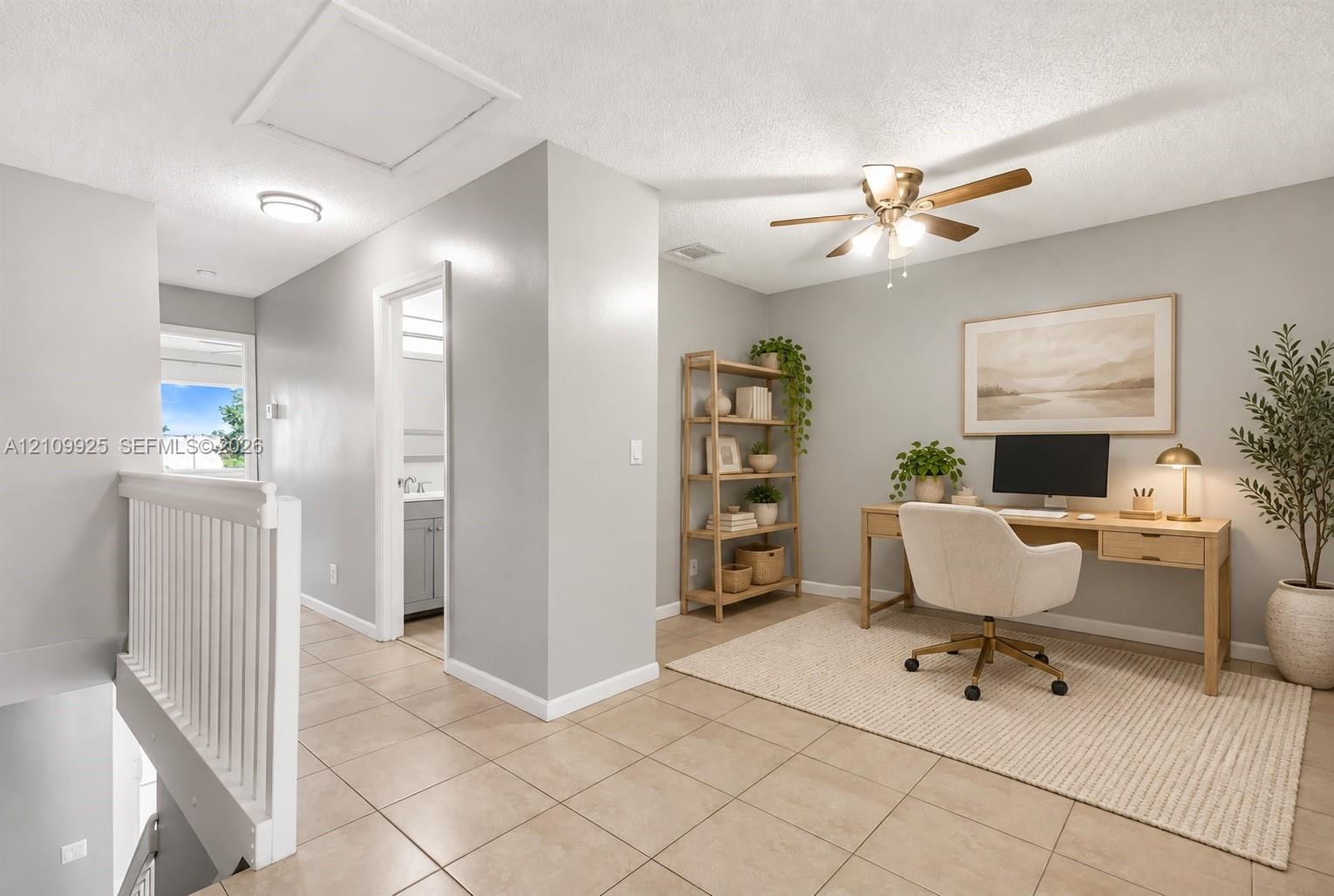 Open-concept space featuring tile flooring, neutral wall paint, and a ceiling fan with integrated lighting
