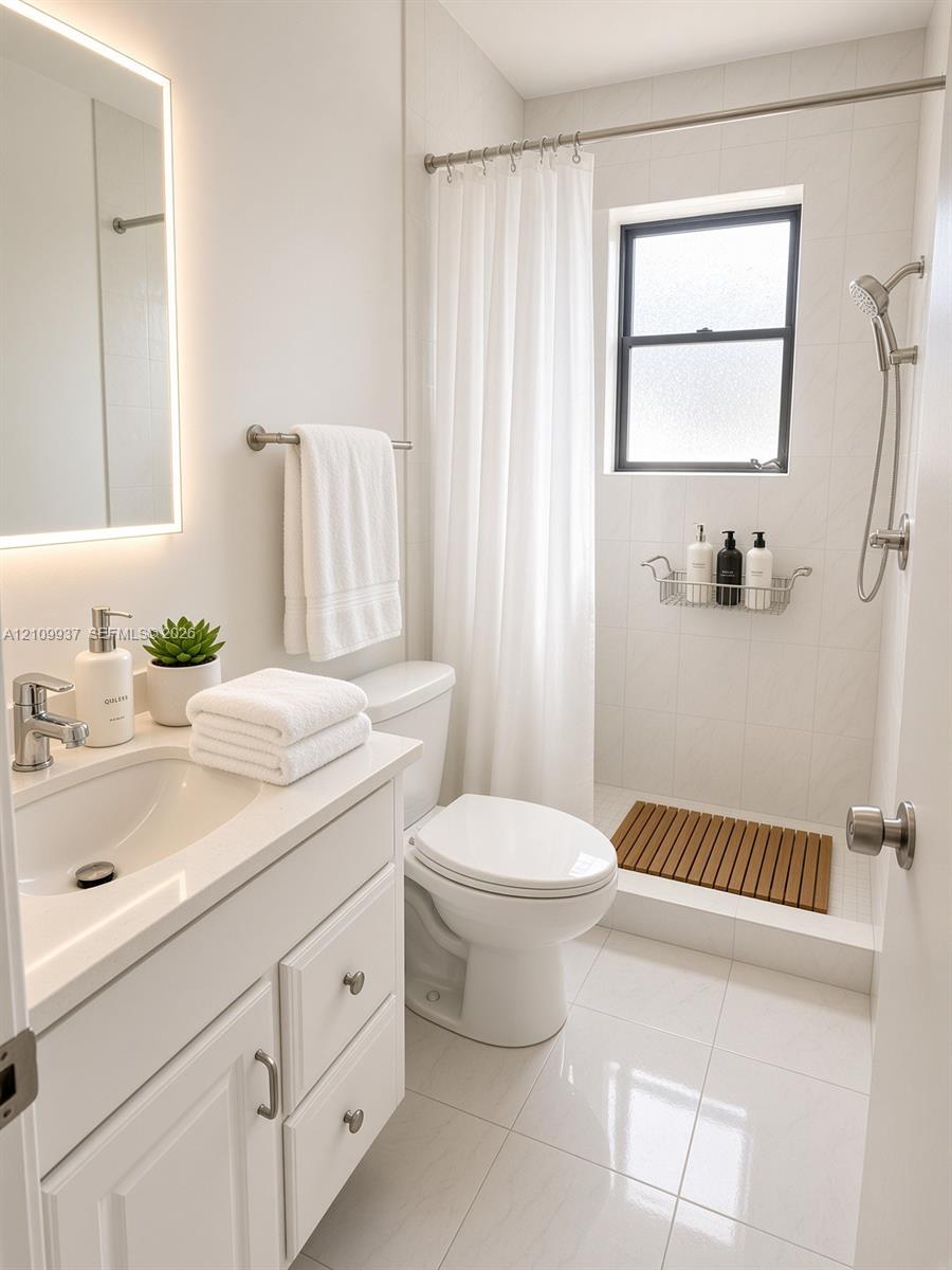 Bathroom featuring a white vanity cabinet, a wall-mounted lighted mirror, polished ceramic floor tile, and a walk-in shower with tiled surround and an adjustable-height handheld fixture