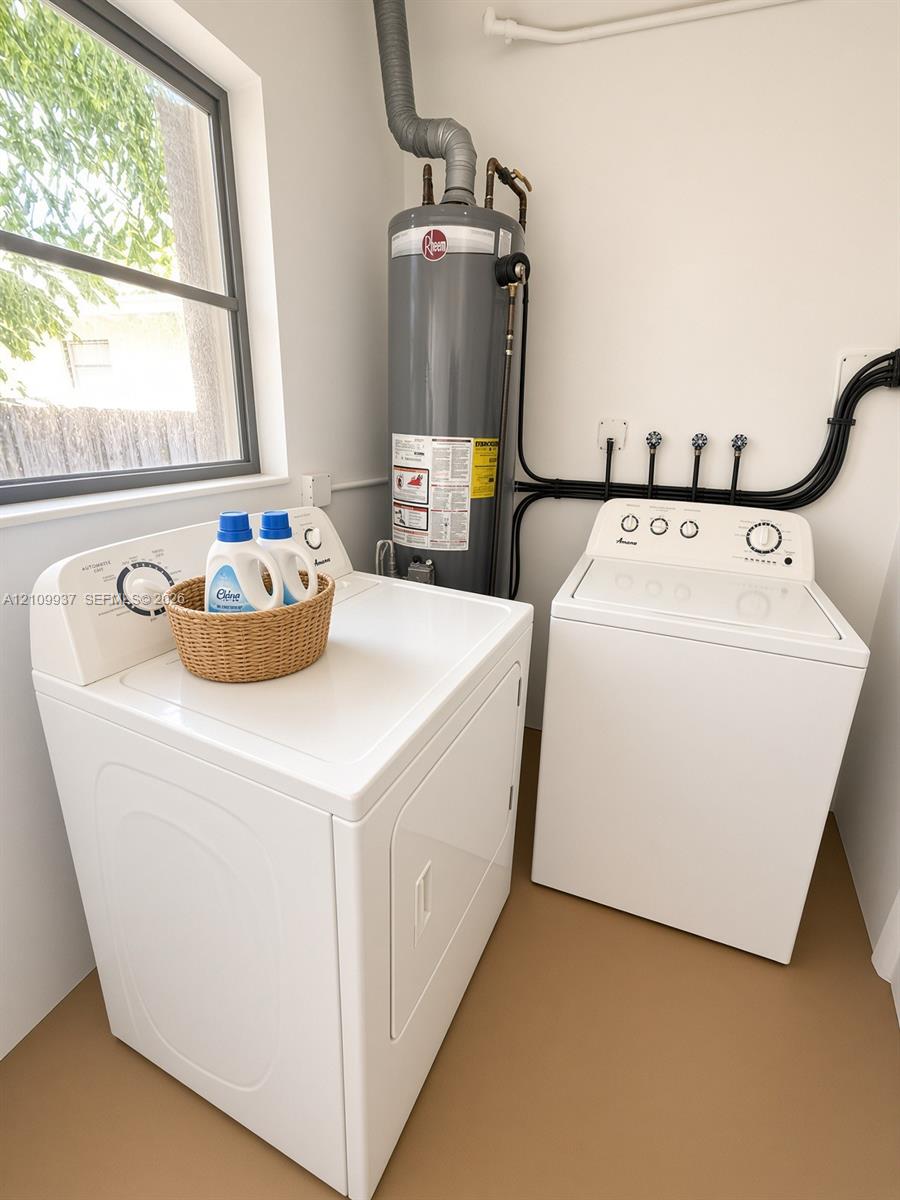 Dedicated utility space featuring a vertical water heater and dedicated appliance hookups, complemented by natural light from a window