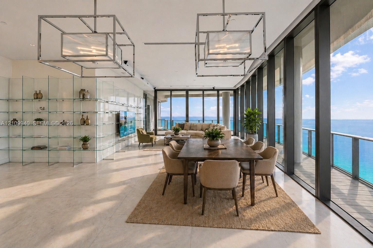 Floor-to-ceiling glass walls, polished stone flooring, custom glass shelving, metallic geometric chandeliers, and a private balcony featuring a water backdrop