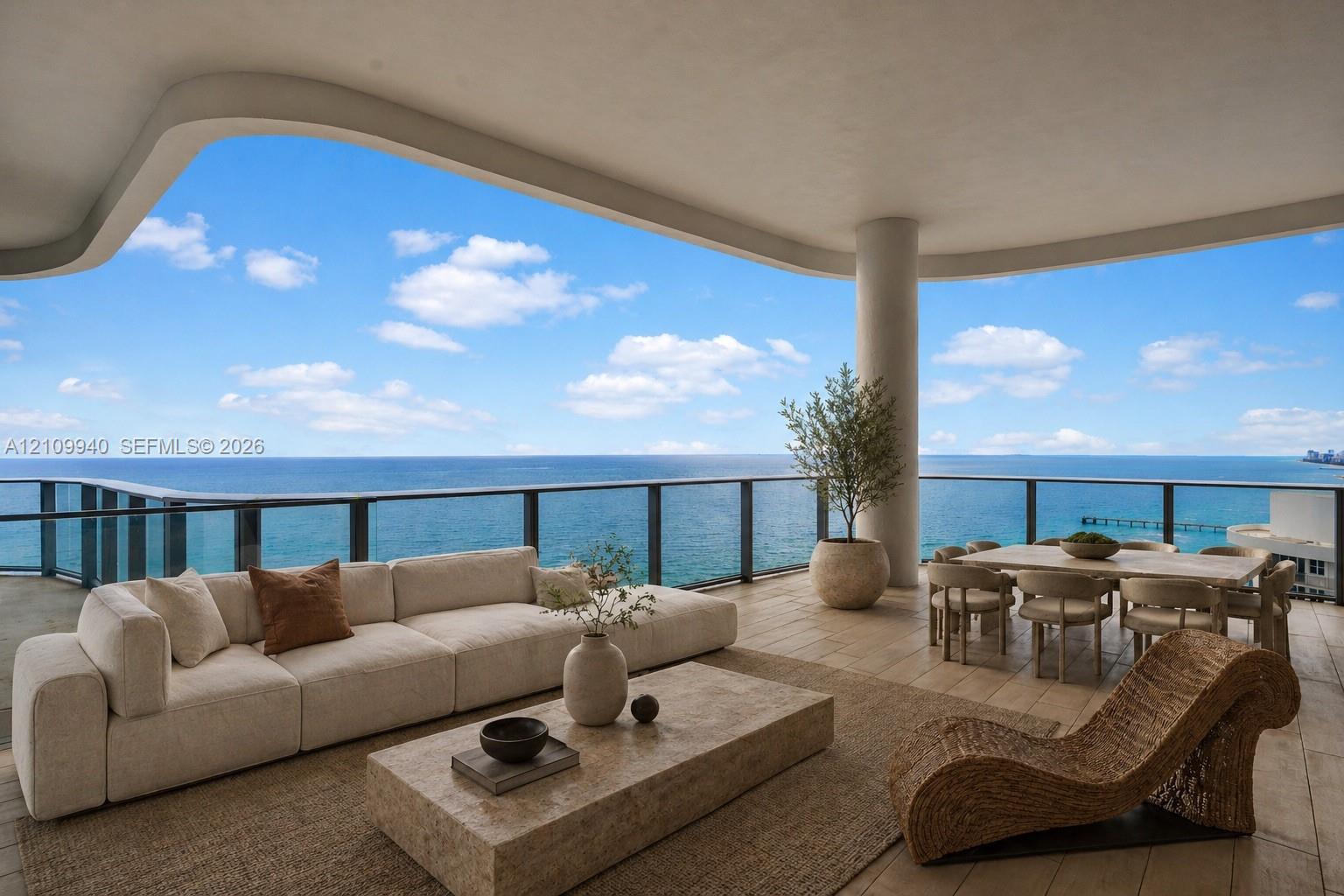 Expansive covered terrace featuring large-format stone flooring, a curved architectural ceiling, and glass panel railing