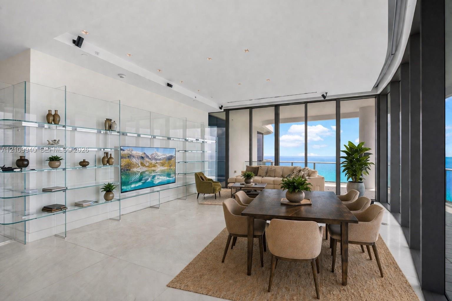 Open-concept living area featuring floor-to-ceiling glass walls, large-format stone-finish flooring, built-in floor-to-ceiling glass shelving, and recessed ceiling lighting