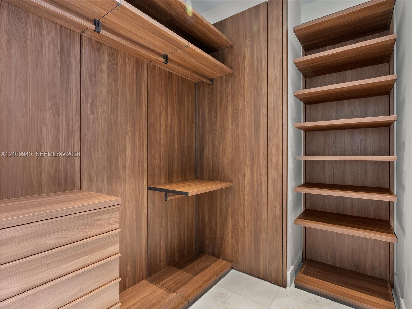 Customized built-in storage system featuring wood-finish cabinetry, integrated shelving, adjustable hanging rods, and a multi-drawer unit