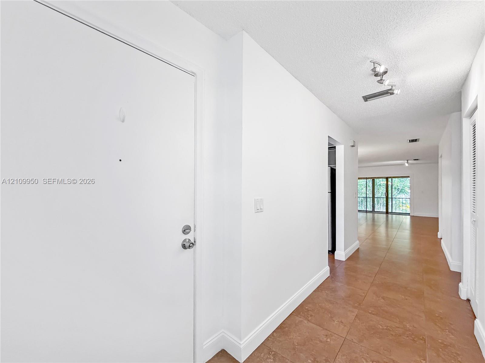 Entryway featuring ceramic tile flooring, neutral wall finishes, and adjustable track lighting