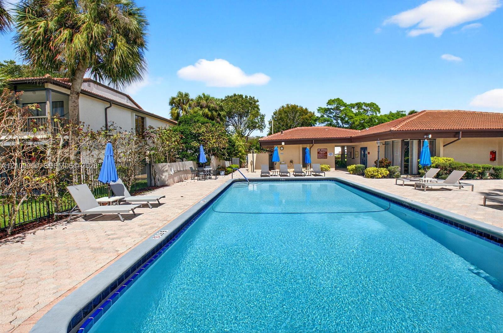Rectangular swimming pool with a tiled perimeter, surrounded by a paved patio area