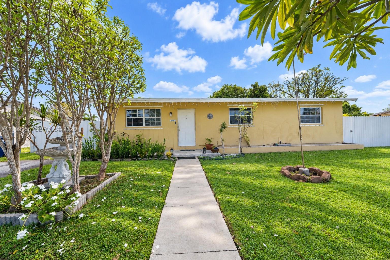 Single-story exterior featuring a stucco facade, concrete walkway, and white privacy fencing Single-story exterior featuring a stucco facade, concrete walkway, and white privacy fencing