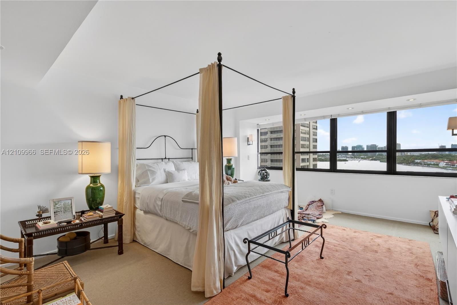 Bedroom featuring expansive floor-to-ceiling windows, neutral carpeting, recessed ceiling lighting, and wall-mounted light fixtures