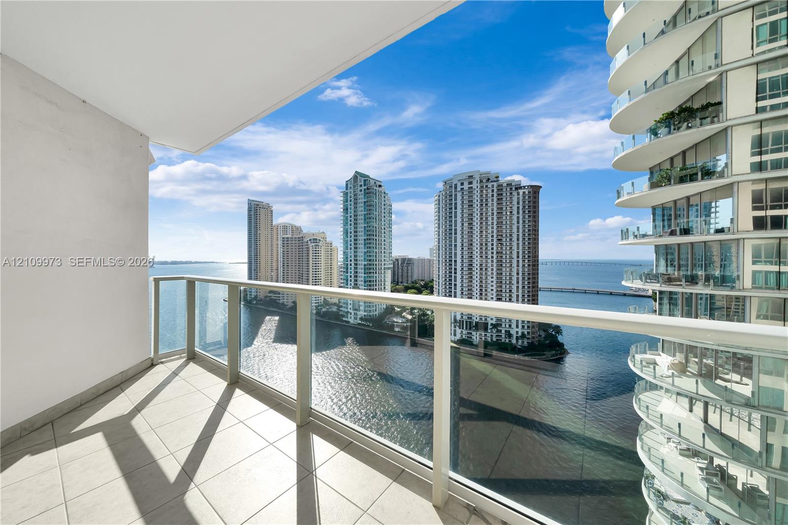 Private balcony featuring white tile flooring and a glass panel railing