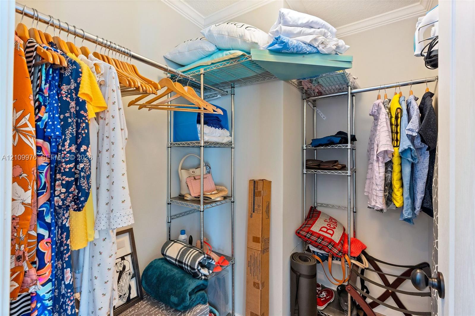 Walk-in closet featuring floor-to-ceiling metal wire shelving and integrated garment rods