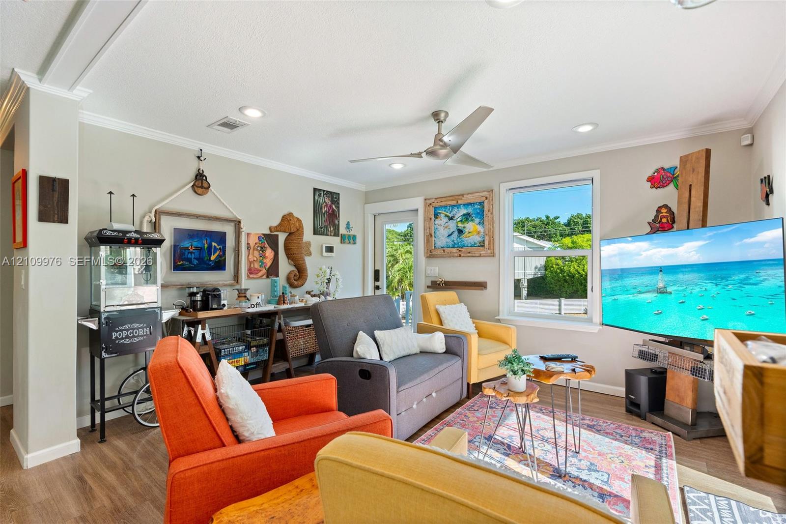 Living area featuring recessed lighting, a ceiling fan, crown molding, wood-finish flooring, and a single-pane window