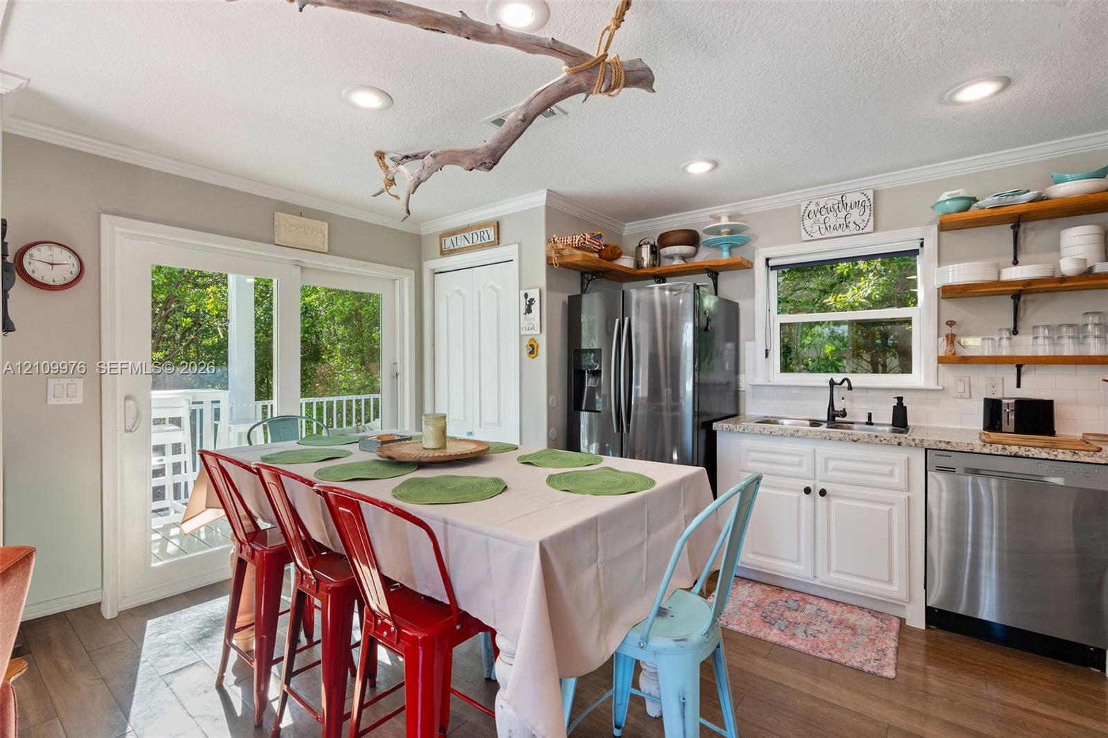 Kitchen featuring white cabinetry, stone-finish countertops, stainless steel appliances, wood-finish flooring, and sliding glass doors