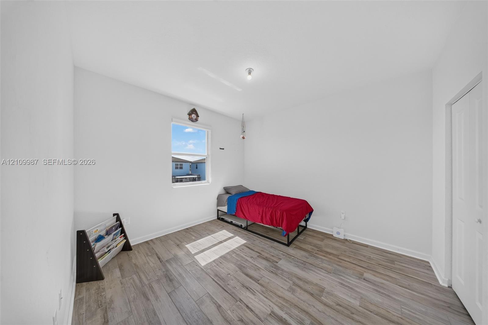 Room with porcelain flooring, white walls, and a multi-panel door
