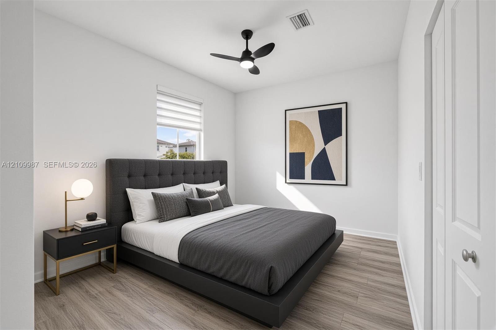 Neutral-toned interior featuring porcelain flooring, a contemporary matte black ceiling fan with integrated lighting, and a single-panel interior door