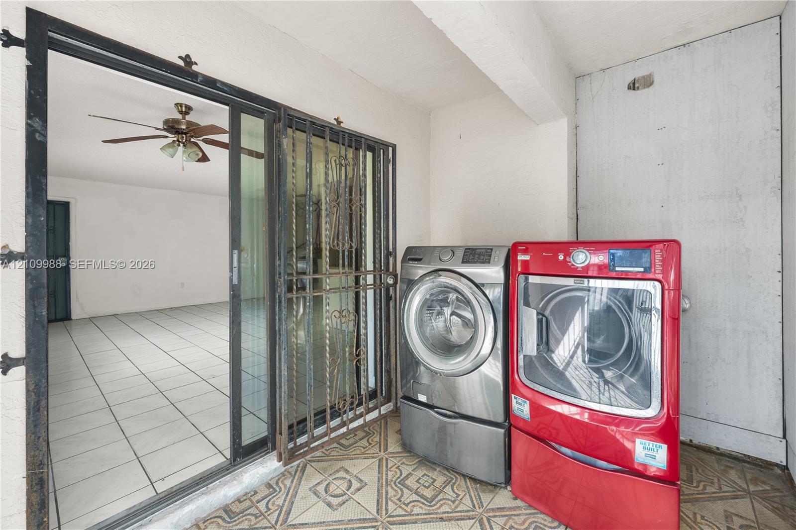 Covered patio featuring patterned tile flooring, a metal security screen door, and a sliding glass door Covered patio featuring patterned tile flooring, a metal security screen door, and a sliding glass door